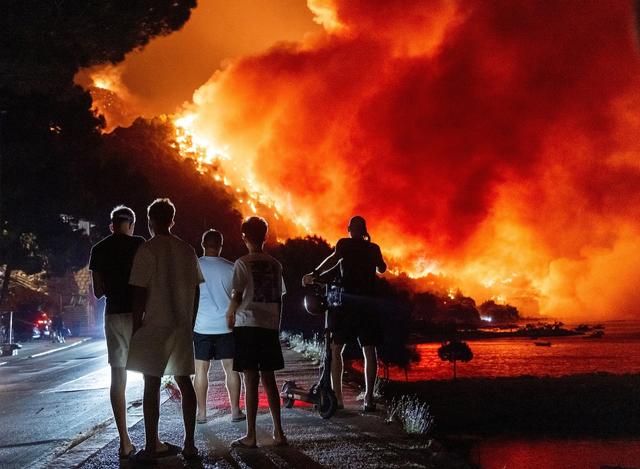 当地时间2026年8月14日，克罗地亚南部奥米什附近，民众眺望亚得里亚海沿岸的野火。视觉中国 图